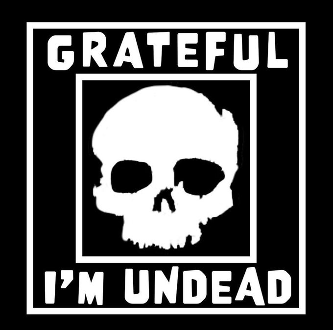 A black and white graphic featuring a skull illustration with the text 'GRATEFUL I'M UNDEAD' displayed prominently above and below the skull within a square border.