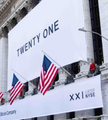 The image shows a white banner reading "TWENTY ONE" displayed above a podium flanked by U.S. flags at what appears to be the New York Stock Exchange (NYSE), where Twenty One Capital recently launched as a Bitcoin treasury company.