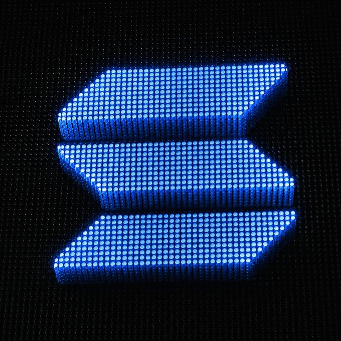 The image shows a glowing blue Solana logo composed of LED-style dots against a black background. It relates to the post by displaying the Solana cryptocurrency's branding, likely to draw attention to the giveaway call-to-action requesting users to share their Solana wallet addresses.