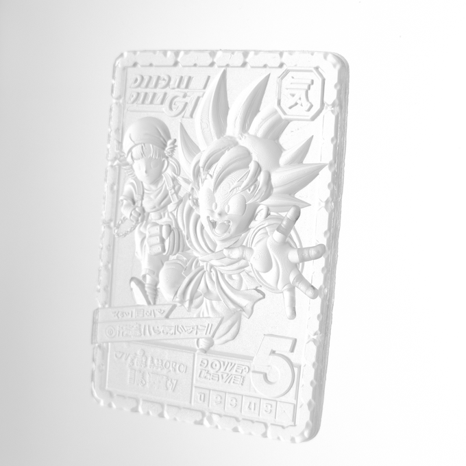 A 3D render of a white embossed trading card or medal featuring an anime-style boy with spiky hair, with the text 'DRAGON BALL', 'GOKU', 'POWER LEVEL', and the number '5' visible.