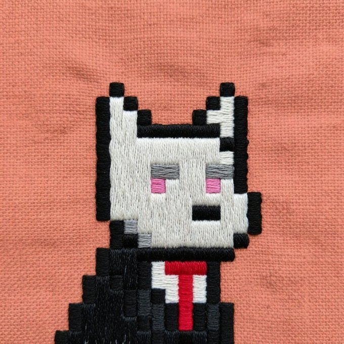 An embroidered patch of a pixelated black and white cat with pink cheeks wearing a red tie, stitched onto a peach-colored fabric.