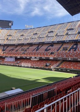An empty Mestalla Stadium, home of Valencia CF, featuring the club's name displayed prominently in the stands, reflecting the team's turbulent era with 18 managerial changes since 2012 and a current 19th-place La Liga standing.
