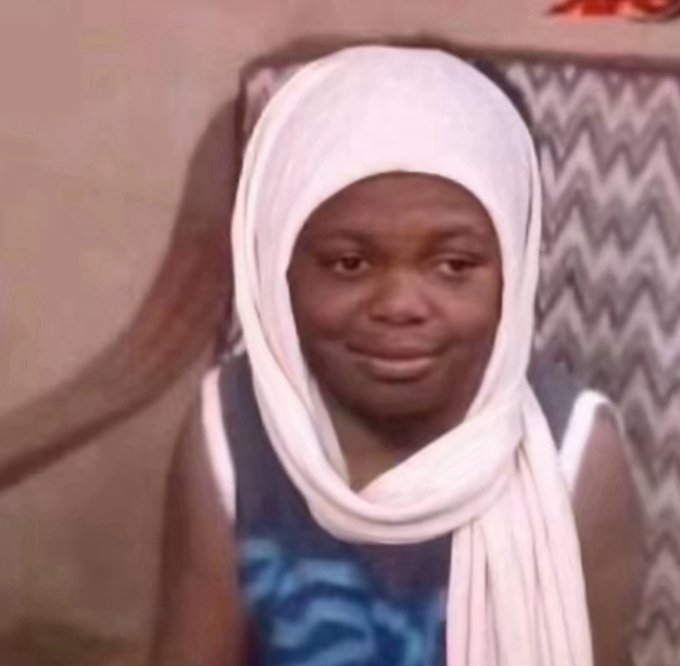 A young girl wearing a white headscarf and blue patterned top smiles warmly while leaning against a chevron-patterned cushion. Her calm, knowing expression perfectly captures the meme's tone of unbothered confidence toward the peer pressure of minting NFTs on the Robinhood chain.