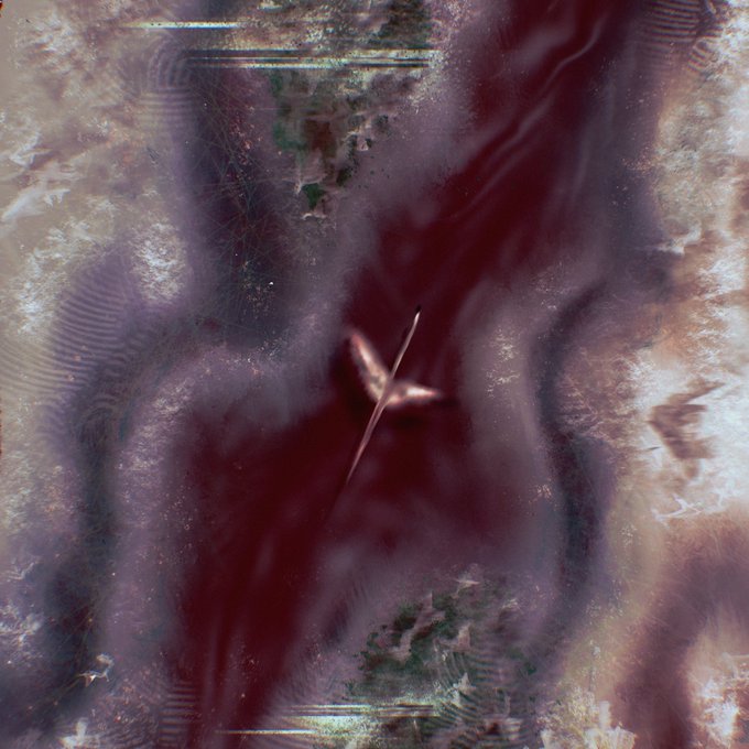 An abstract, hazy composition with deep red and purple tones, featuring faint textures, swirling patterns, and small, blurred triangular shapes.