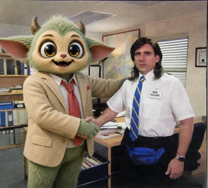 A person in a furry green monster costume wearing a tan suit and red tie shakes hands with an office worker wearing a 'NEW HOLDER' name tag and blue fanny pack.