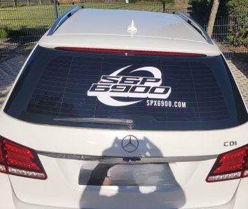 The rear of a white Mercedes-Benz car with a large SST 690 decal on the back window and the website SPX690.COM displayed beneath it.