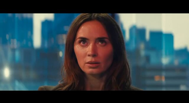 The image features a woman with long brown hair, looking up at something or someone off-camera. She appears to be wearing a black jacket. The background of the image shows a city skyline, suggesting that she might be in an urban setting. There is also text present in the image, which reads "Make Aliens Great Again $MAGA". This could possibly be related to a movie or TV show featuring the character from the film "Aliens", where the main character is named after her mother's name.