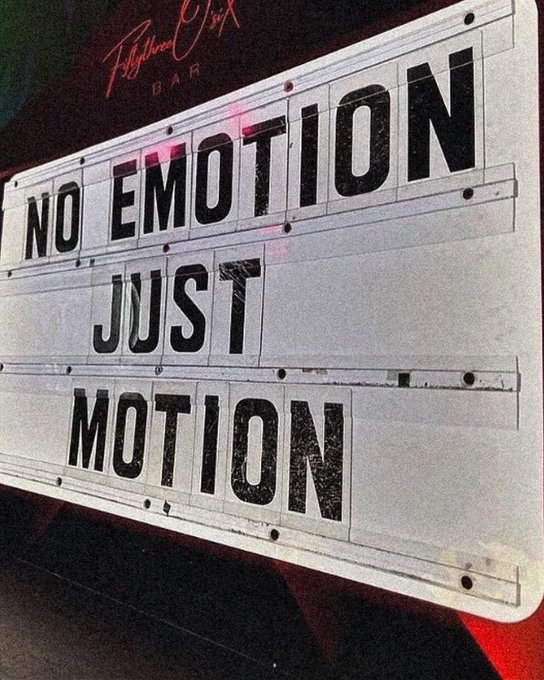A photograph of an illuminated marquee sign outside a 'Polymath Six Bar' that reads 'NO EMOTION JUST MOTION' in bold black letters on a white background.