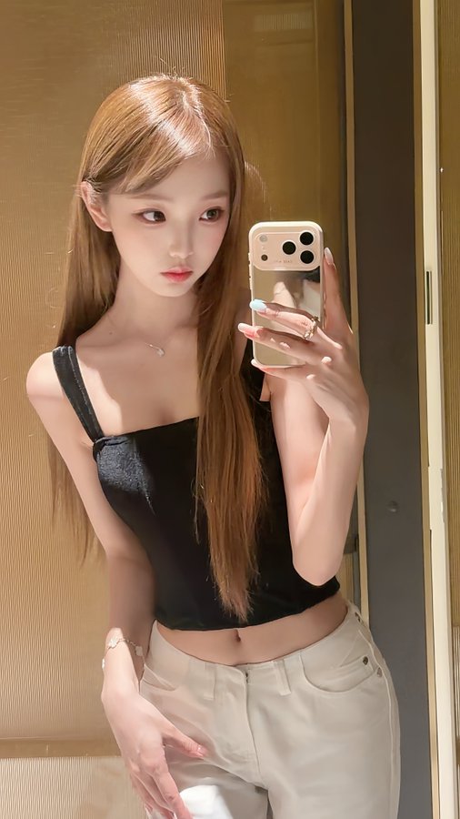 A young woman with long auburn hair takes a mirror selfie in a black tank top and white pants, holding an iPhone, in an image that has no clear connection to the post's discussion about allocating 1 million USDT and crypto market liquidity.
