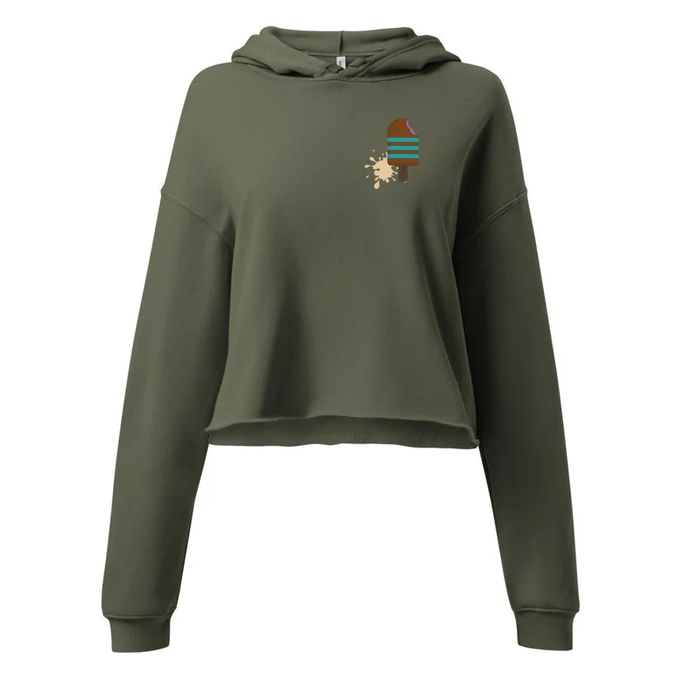 An olive green cropped hoodie on a white background featuring a small embroidered design of a patterned beanie with a flower.