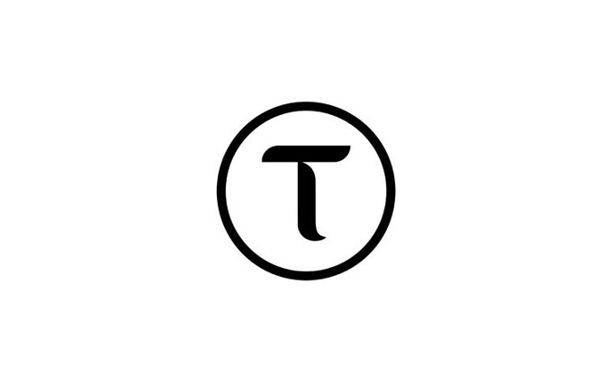 A black circular logo featuring a stylized letter "T" inside, representing the Bittensor ($TAO) cryptocurrency brand. The minimalist emblem serves as visual branding for the post discussing Bittensor's current shortcomings and developmental gaps.