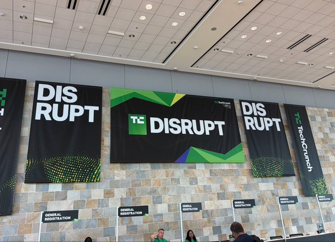 Registration area of a 'TC TechCrunch Disrupt' event featuring multiple 'GENERAL REGISTRATION' signs and large branded banners.