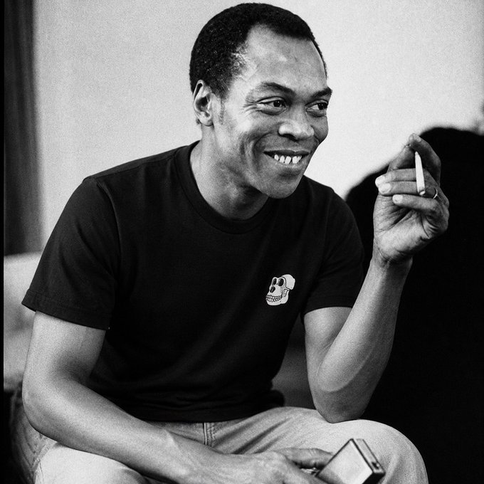 The image features a man sitting down with his arms crossed while holding a cigarette. The photo has been edited to appear black and white, giving it an artistic touch. The caption below the image reads "BAYC will always remain the most prolific IP to come out of crypto. With Pokémon collectors numbering in the millions, 30,000 assets simply isn' enough for everyone. At some point, scarcity will kick in. And that'S not even considering the clubhouse, ApeFest, networking". The man's pose and the cigarette he holds suggest a relaxed atmosphere or perhaps a moment of contemplation as he enjoys his time with the Pokémon community.