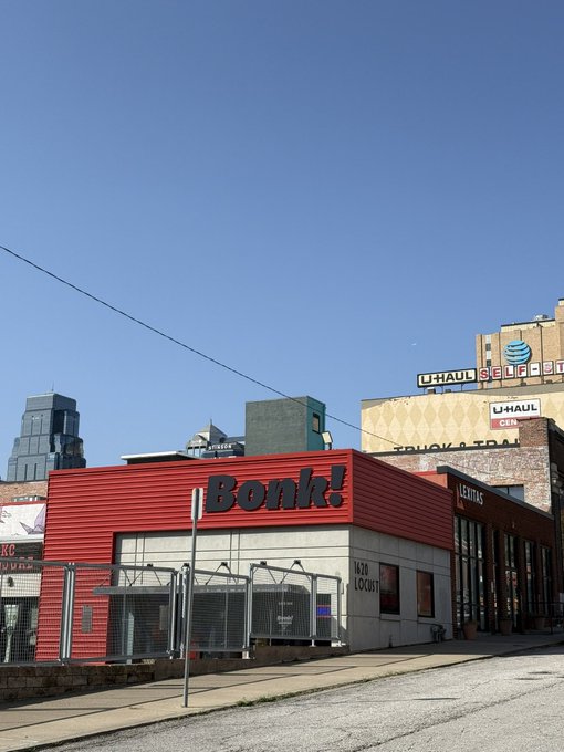 An outdoor daytime photograph of a red building prominently labeled 'Bonk!' on the side, located next to an 'EXITAS' sign with an AT&T and U-Haul Self Storage building visible in the background.