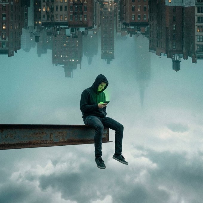 A hooded figure sits on a steel beam high above the clouds, absorbed in a glowing phone, with an inverted cityscape hanging upside-down above them—visually capturing the "no noise up here" sentiment of serene isolation above the urban chaos below.