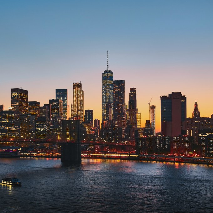 The Manhattan skyline glows at sunset with One World Trade Center towering prominently above the city, as the Brooklyn Bridge stretches across the East River below.

This image of NYC serves as a fitting backdrop for a pivotal moment when senior staff from leading AI companies will testify before the New York City Council on the risks and regulation of advanced artificial intelligence.
