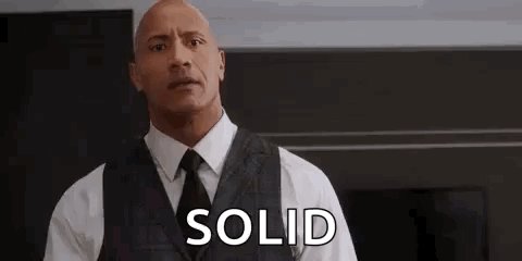 The image shows a man wearing a suit jacket, tie, and vest standing with his arms crossed behind him against a black background. There are two instances of text that read "Solid" placed at different parts within the image; one near the left side in white letters and another closer to the right side in red letters. The overall theme is focused on promoting a specific product or idea related to Bitcoin, emphasizing its importance, value, and simplicity for investors.