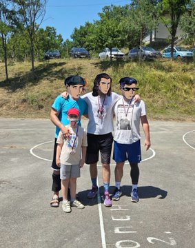 Four men pose together on an outdoor basketball court after winning a 3x3 local tournament, with one wearing a red cap and another sporting a lanyard, under bright sunlight with cars visible in the background. The image's celebratory group shot matches the post's mention of winning the local tourney, while the "Backpack sox" complaint playfully refers to the mismatched or worn socks visible on some of the players.