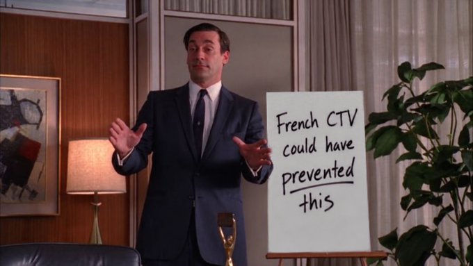A man in a dark suit gestures with open hands in a mid-century office setting, standing beside a presentation easel displaying the handwritten sign "French CTV could have prevented this." The image humorously references a fictional security catastrophe, complementing the post's critique of overly complex "Rube Goldberg" security architectures by suggesting simpler solutions exist.
