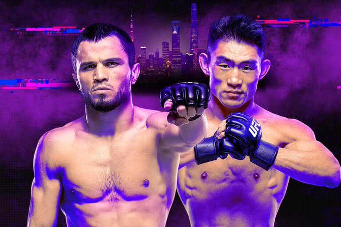 A promotional fight poster features two shirtless MMA fighters, one Caucasian and one Asian, posing with fighting gloves against a purple background with a city skyline.