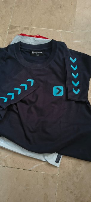 A navy blue 'movewear' athletic shirt with turquoise chevron patterns on the sleeves, laid flat on a tiled floor.