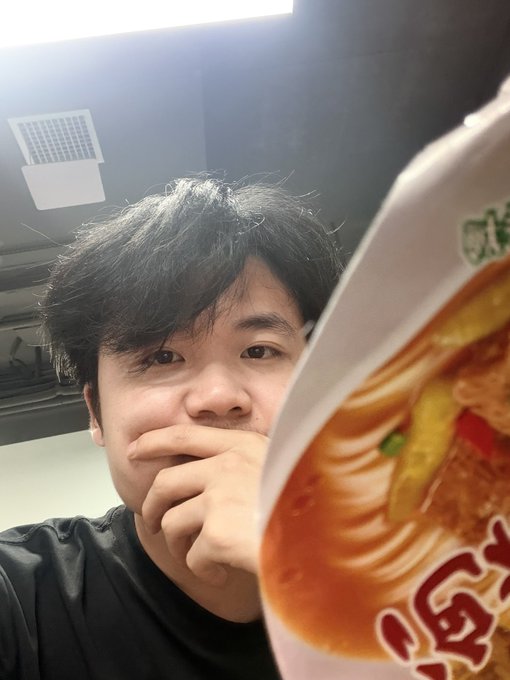 A young man covers his mouth while staring dejectedly at a cup of instant noodles (specifically "香辣牛肉面"/spicy beef flavor), with the Chinese text "买泡面吃" (buying instant noodles to eat) in the post humorously emphasizing his self-deprecating jab about his losses. The image visually captures the punchline—a defeated trader settling for cheap ramen after being wiped out by market volatility.