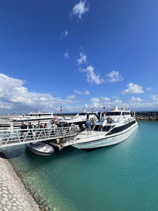 A "Cancun Express" ferry docked at a pier under bright blue skies, with passengers boarding and turquoise Caribbean waters in the foreground—capturing the relaxing tropical getaway vibe referenced in the post's theme of recharging and enjoying peaceful moments.