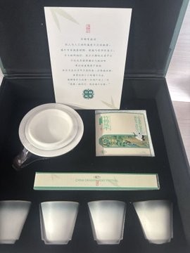 The image features a black box containing four cups, each with a unique design. The cups are arranged neatly inside the box, showcasing their artistic details. The boxes themselves appear to be made of wood or cardboard, giving them an authentic and rustic appearance. The cups seem to be placed in such a way that they can be easily admired by viewers.