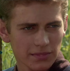 A close-up portrait of a young man with curly blonde hair and blue eyes, appearing to be from a vintage film or television scene.
