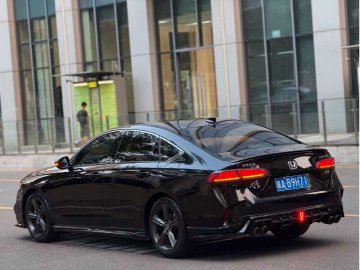 A black Mercedes-Benz sedan parked on a street in front of a modern glass building, displaying a license plate that reads 'MARHABA'.