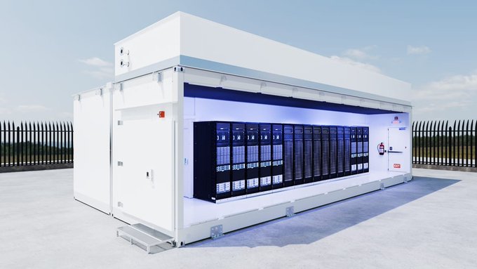 A large white container-style data center housing rows of black server racks is installed on a concrete surface surrounded by a metal fence.
