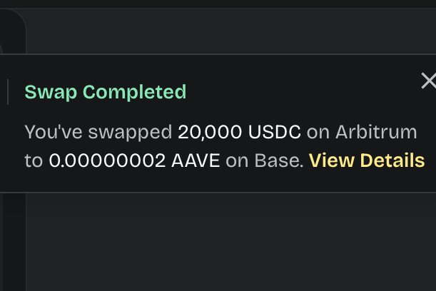 A screenshot of a 'Swap Completed' notification indicating a swap of 20,000 USDC on Arbitrum to 0.00000002 AAVE on Base, with a 'View Details' link.