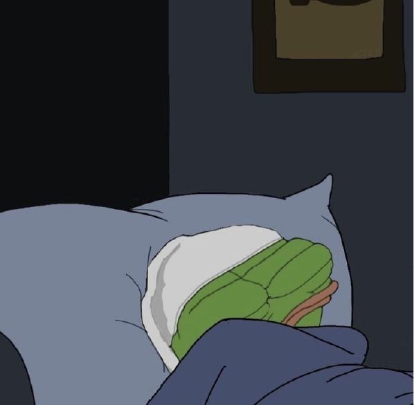 A cartoon scene showing the green hand of a character resembling Shrek tucked into bed under blue blankets with a pillow and a framed picture on the wall.