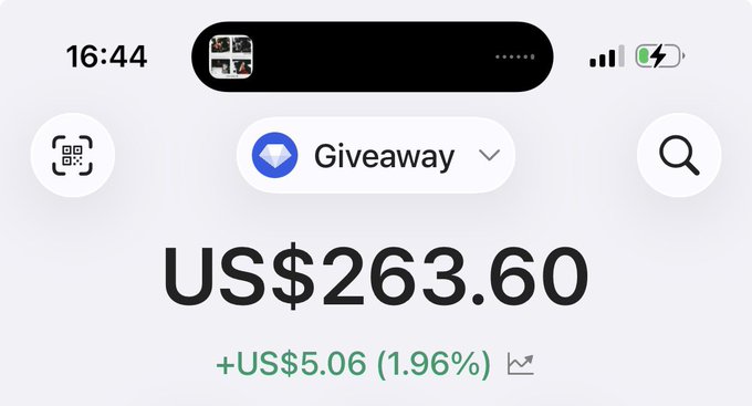 A mobile screenshot displays a cryptocurrency wallet showing a "Giveaway" account balance of US$263.60, up +US$5.06 (1.96%). The image visually reinforces the post's message by showing available funds ready to be given away to active community members.
