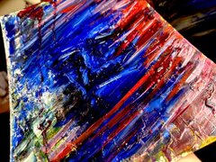 An abstract painting featuring bold, energetic strokes of blue, red, white, and black with heavy texture.
