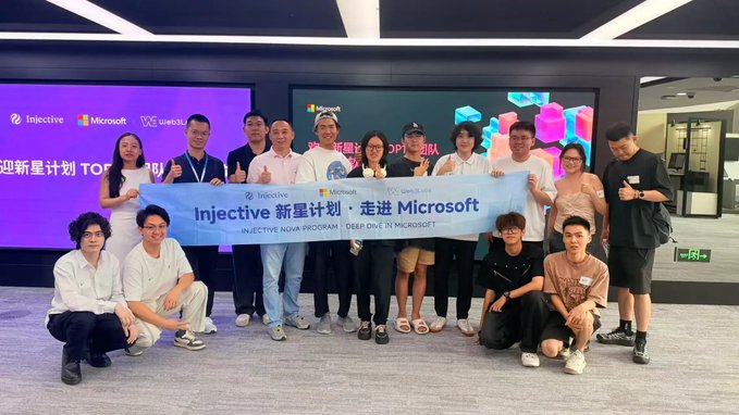 A group photo of people posing together at a Microsoft/Injective event, holding a banner that reads 'Injective 新星计划 · 走进 Microsoft' and 'INJECTIVE NOVA PROGRAM - DEEP DIVE IN MICROSOFT'.