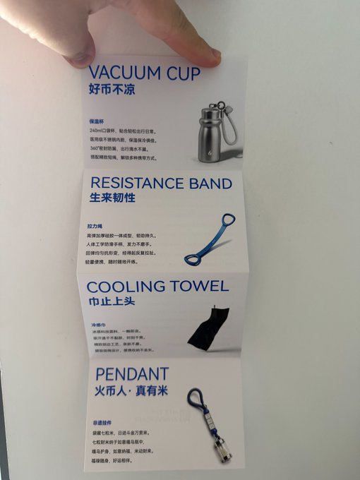 A hand holds up a product information card displaying four items with both English and Chinese text: VACUUM CUP (好币不凉), RESISTANCE BAND (生来韧性), COOLING TOWEL (巾止上头), and PENDANT (火币人·真有米), each with accompanying product images and Chinese descriptions.