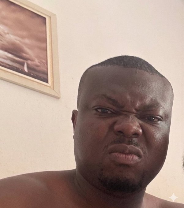 A shirtless man with a skeptical, side-eye expression appears in a selfie, with a framed painting visible on the wall behind him. His doubtful, pouting look humorously matches the post's caption, which jokingly questions whether followers made "5 figs" from a meme while he was asleep.