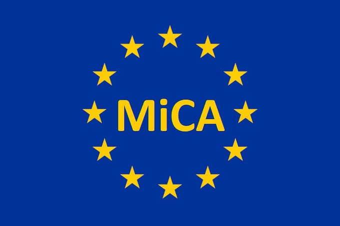 The image features the European Union flag's iconic blue background with twelve yellow stars arranged in a circle, overlaid with the bold yellow text "MiCA," referencing the EU's Markets in Crypto-Assets Regulation. It visually represents the regulation referenced in the post about Austria issuing its first published MiCA penalty against Bitpanda, symbolizing the shift of MiCA from theory to enforcement.
