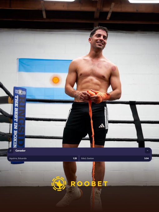 A shirtless male boxer in black shorts stands in a boxing ring wrapping his hands with orange tape, with an Argentine flag behind him and a 'ROOBET' branded livestream overlay showing odds for 'Aguirre, Eduardo' and 'Edul, Gaston'.