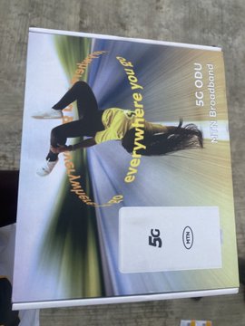A textbook titled "5G C2C" and "NMS Broadband" with the tagline "everywhere you l..." displayed on the cover, resting on a wooden surface.