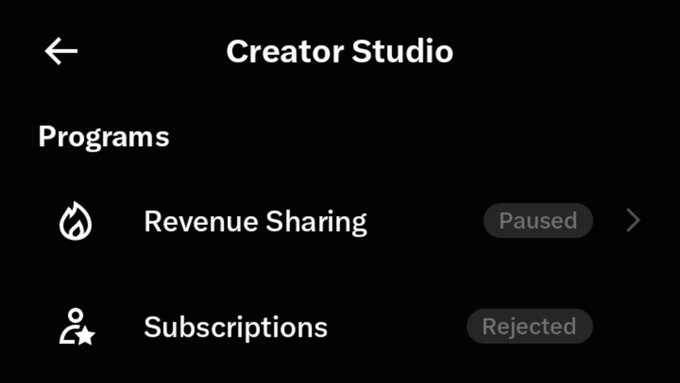 A dark-mode Creator Studio interface showing two programs: Revenue Sharing (status: Paused) and Subscriptions (status: Rejected).