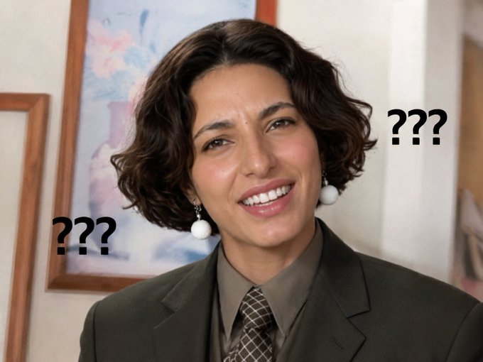 An AI-generated image of a woman with short dark hair wearing a green suit and tie, smiling with '???' text placed on both sides of her face, suggesting she is an AI or mystery figure.