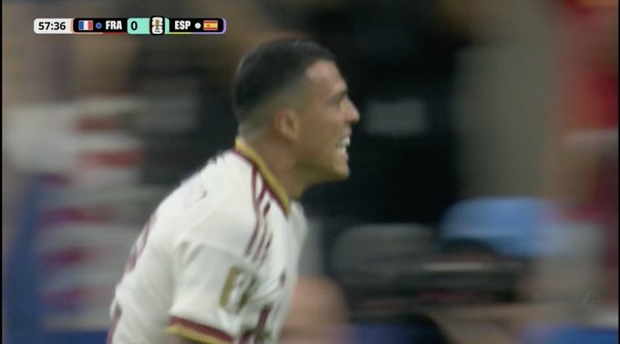 A football player in a white and gold jersey with "Fly" visible is shown in a broadcast screenshot with the scoreboard reading FRA 0 - ESP at 57:36, likely from a UEFA match.