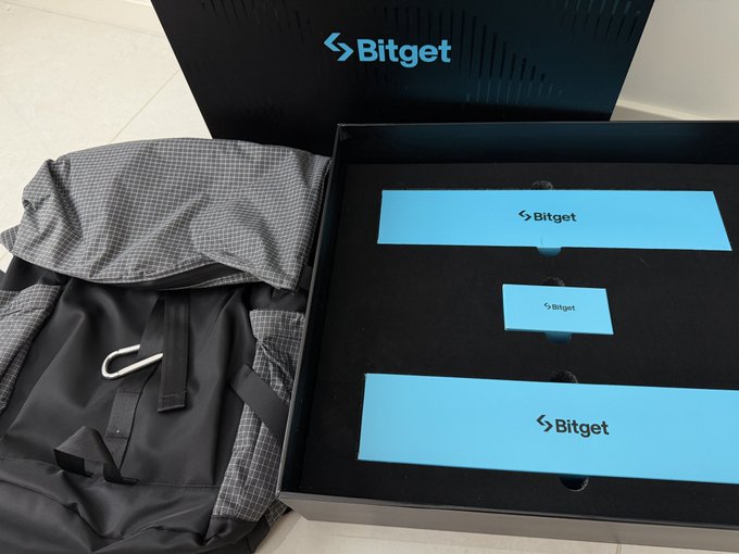 A Bitget promotional package containing a black backpack and three branded boxes with the Bitget logo.