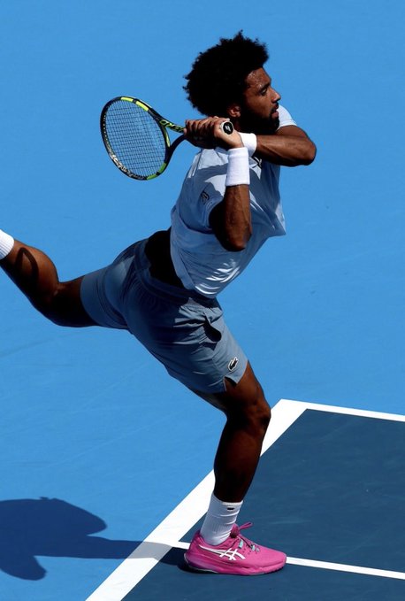 A tennis player in a light blue outfit with bright pink shoes follows through on a swing on a blue hard court. The image visually reinforces the post's reference to the US Open qualifying matches, where an unusually successful prediction wallet has reportedly placed $105K in wagers that the general betting public has overlooked.