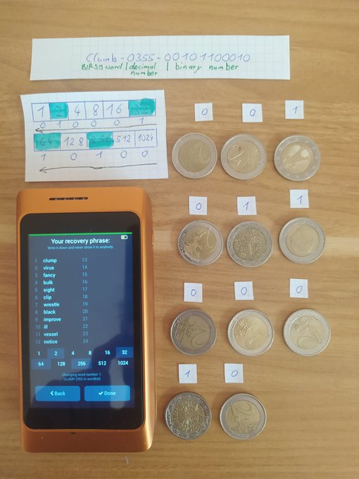 A hardware wallet displays the recovery phrase "clump toss fancy bulk eight rib wrestle black improve trap vessel notice" alongside a hand-written conversion of the BIP-39 word "clump" (index 0355) into the decimal number 1100010, with corresponding binary digits placed on coins to demonstrate the manual conversion process that the Specter DIY wallet automates.