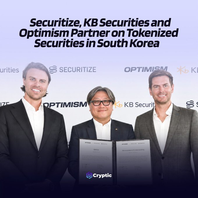 Three executives from Securitize, KB Securities, and Optimism pose together holding signed memorandums of understanding, marking their partnership to bring tokenized securities to institutional investors in South Korea.