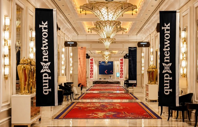 An elegant hotel hallway set up for an event, featuring tall black banners reading "quipnetwork" flanking a red carpet, with "TOSHIBA" banners and a central screen displaying "Welcome to Quip Network" in the background.

The image showcases a sophisticated event venue prepared for Quip Network, aligning with the post's message about quantum computing evolving from theoretical research into real-world Web3 applications and community gatherings.