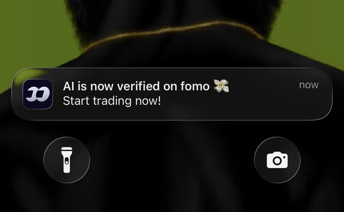An iPhone notification screenshot from the fomo app reading 'AI is now verified on fomo 🦋 Start trading now!' displayed over a background showing a person in a dark jacket.